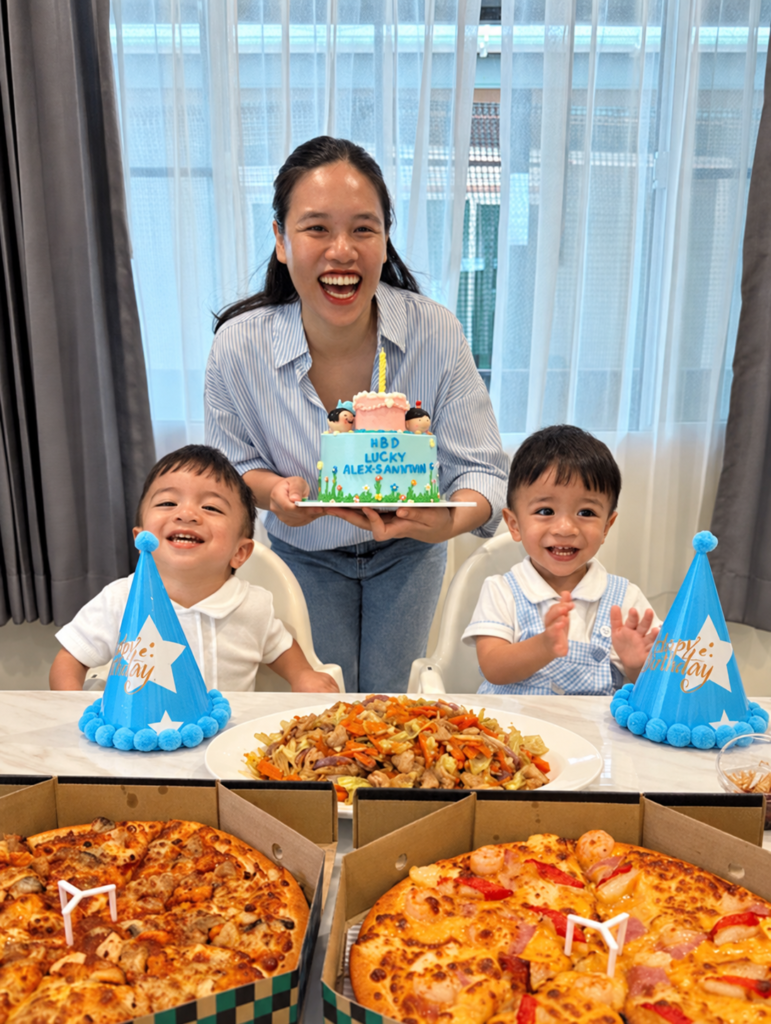 A woman and two children smiling at a birthday table