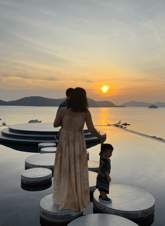 A woman and children overlooking the sea at sunset