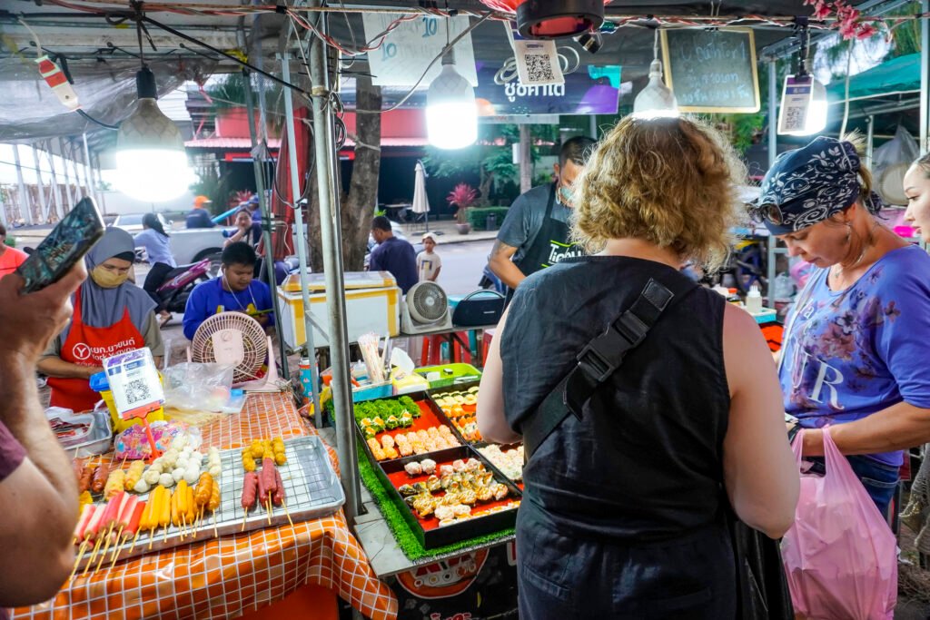 Customers choosing food from a busy local market stall